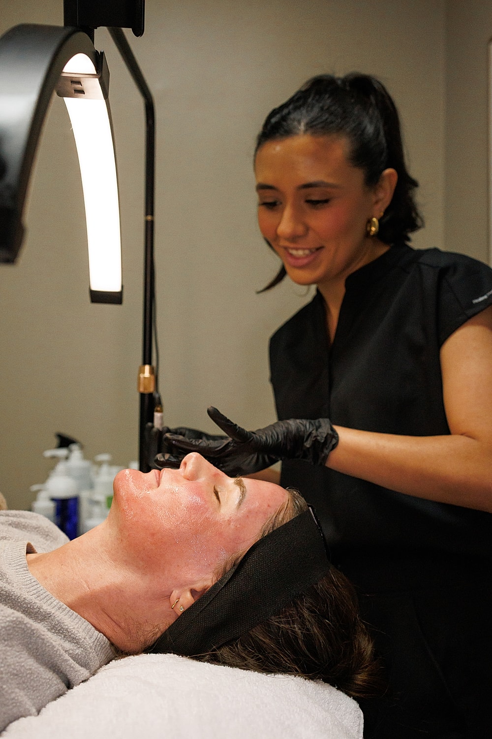 Smiling woman with wavy red hair and earrings.
